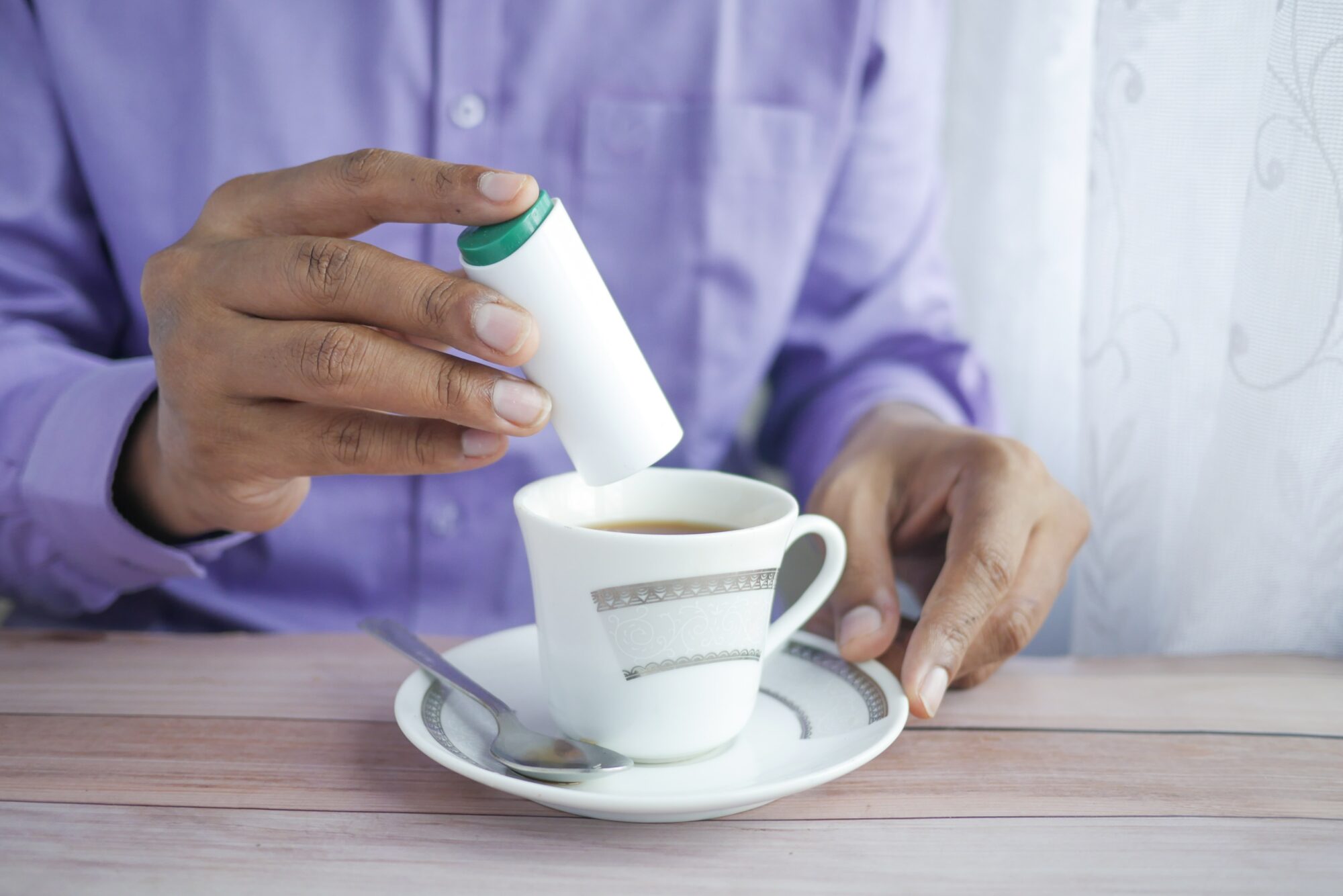 adding a sweetener to coffee