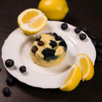 Close up - Lemon Blueberry Mug Cake with lemon wedges on the side.