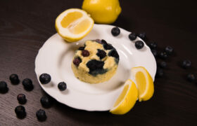 Close up - Lemon Blueberry Mug Cake with lemon wedges on the side.