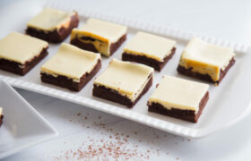 White tray filled with Cheesecake Brownies.