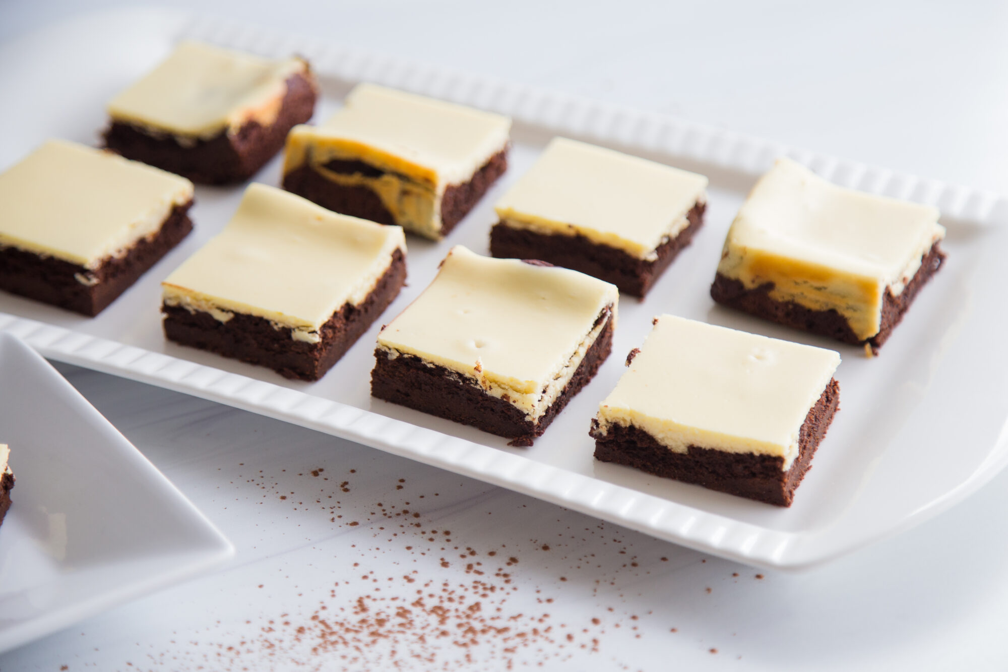 White tray filled with Cheesecake Brownies.