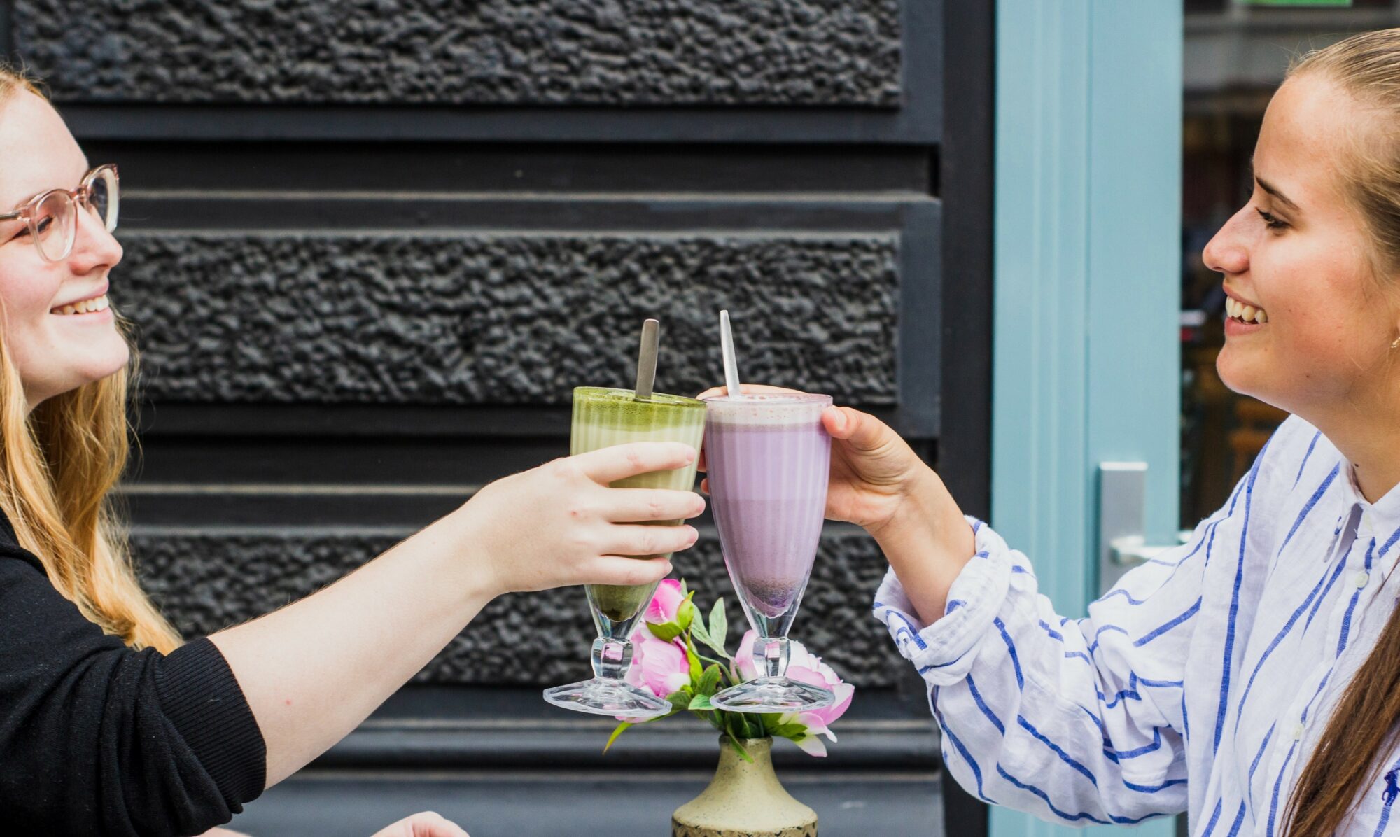 women clinking milkshakes