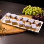 White tray with squares of Peanut Butter Blondies with Grape Frosting.