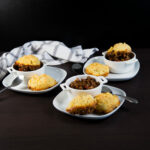 Three ramekins filled with Sloppy Joe Casserole, topped with cobbler biscuits.