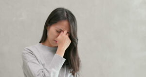 woman pinching bridge of her nose