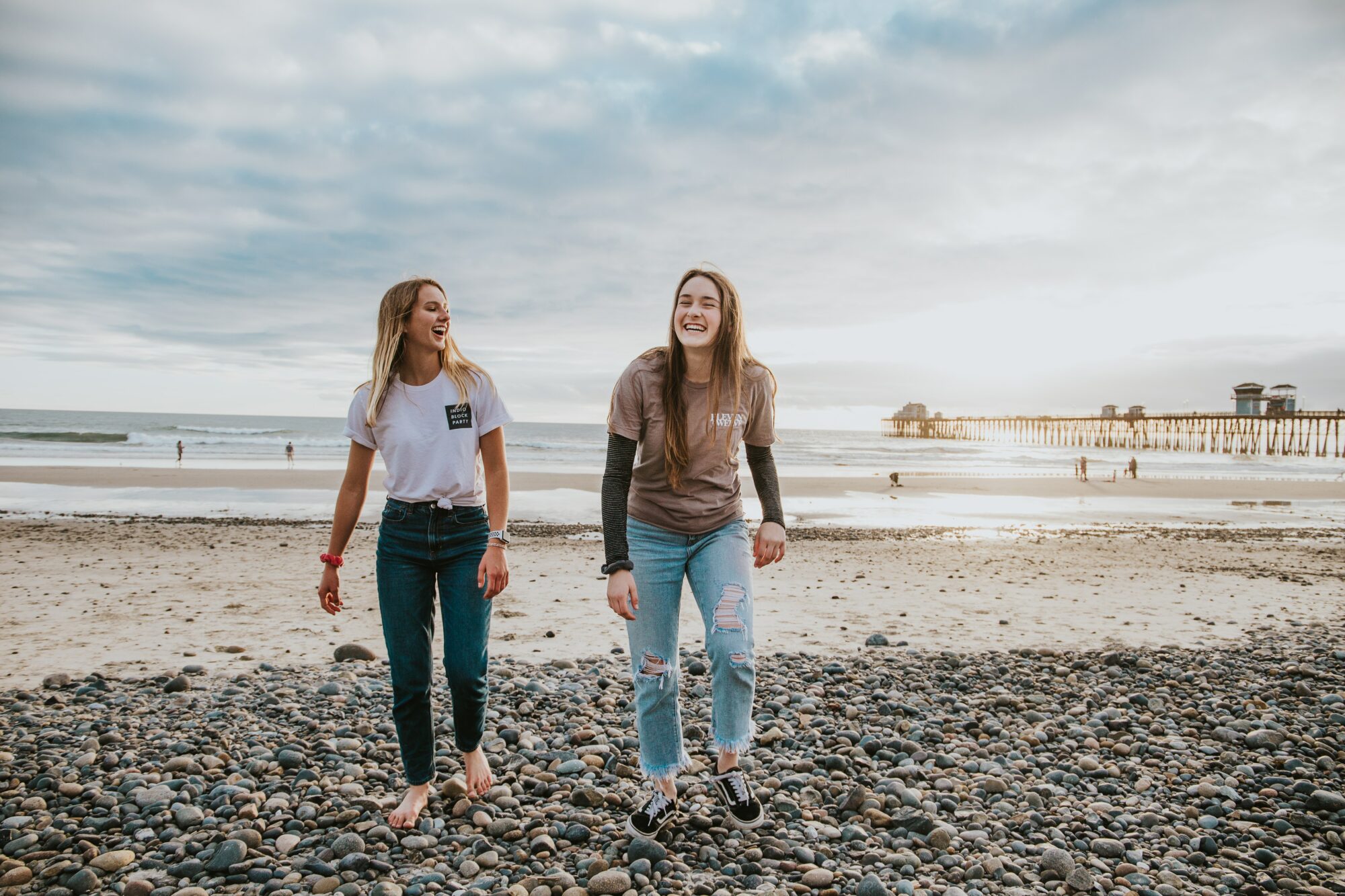 women standing on beach smiling