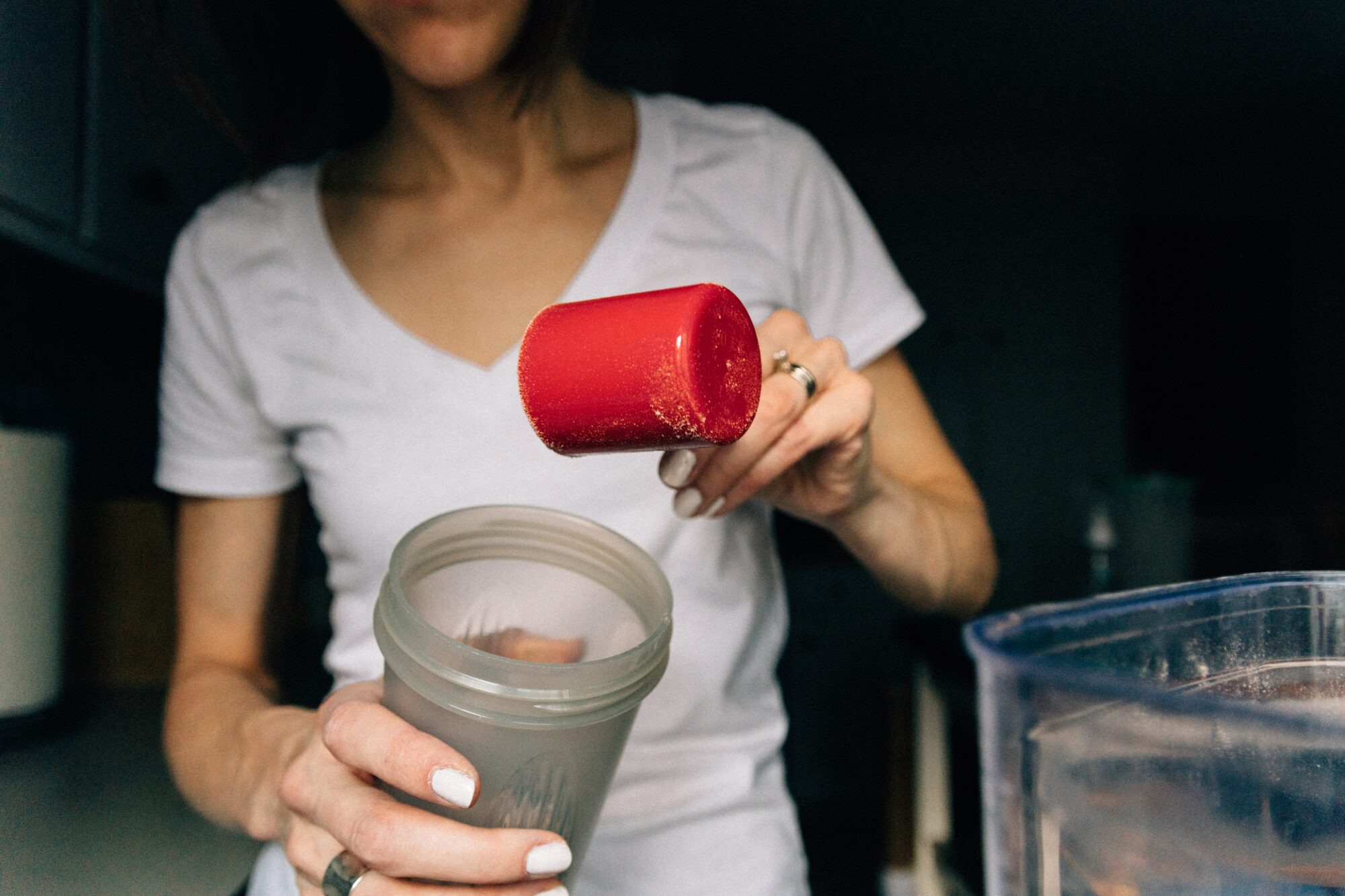 woman pouring protein powder 