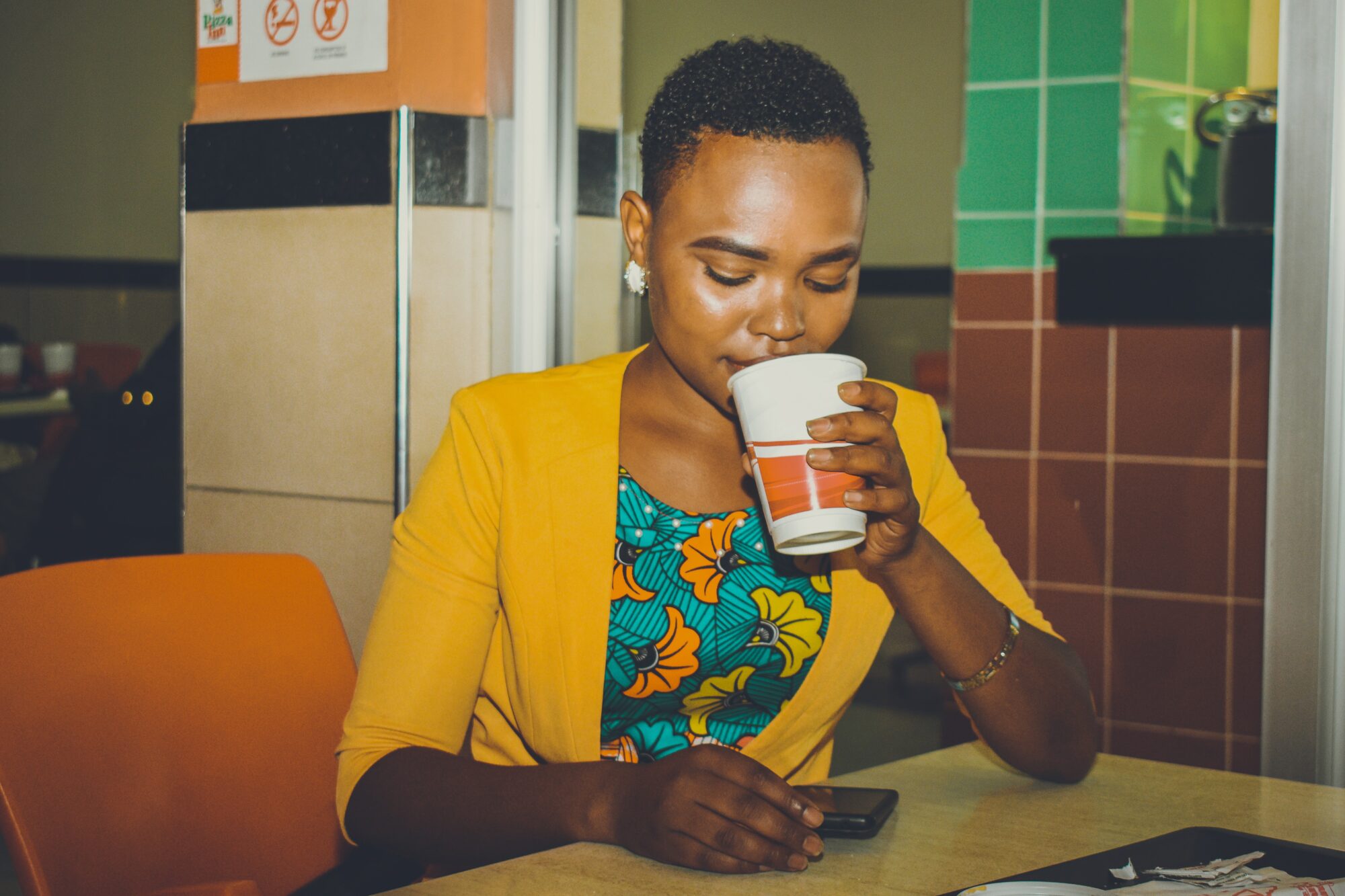 woman drinking while texting