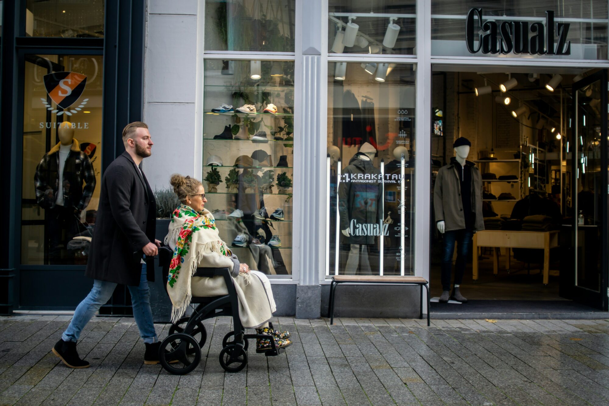 man pushing an elderly woman in wheelchair