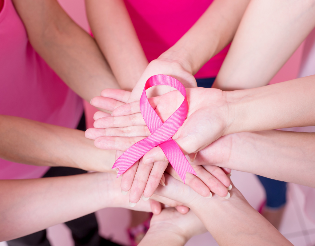 people holding up pink ribbon representing cancer