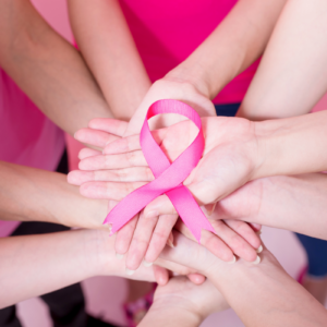 people holding up pink ribbon representing cancer